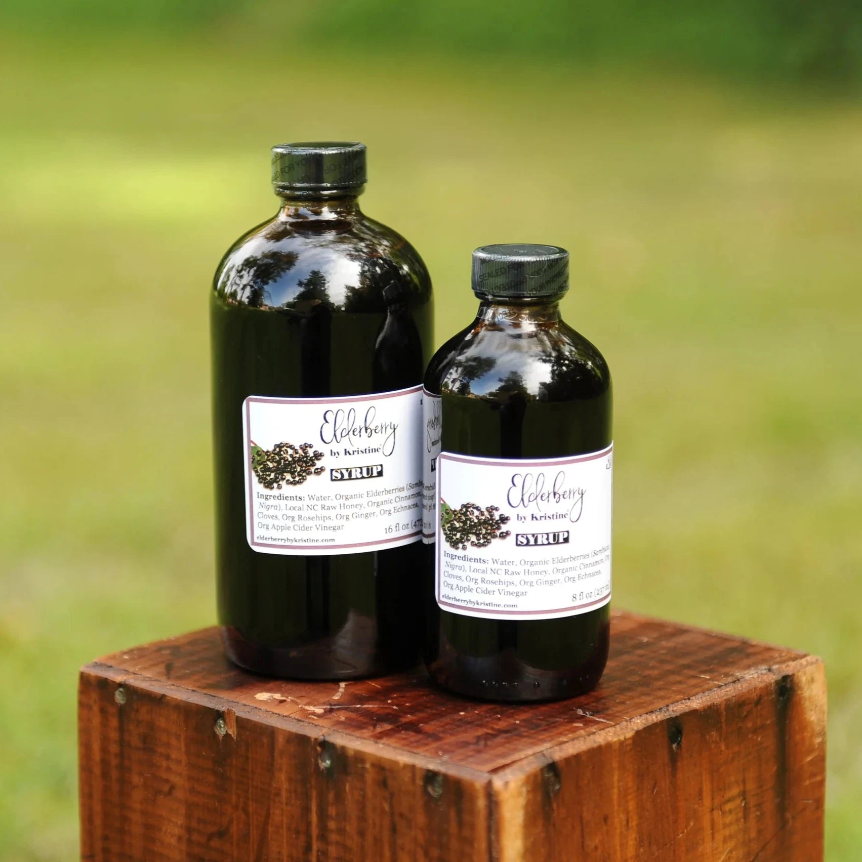 Carolina Elderberry Company Original Elderberry Syrup product photo, small-batch refrigerated elderberry syrup made with organic elderberries, warming spices, and local North Carolina raw honey in a bottle on a clean kitchen counter.